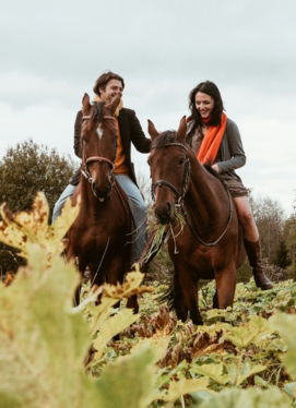 woman in black jacket riding brown horse during daytime